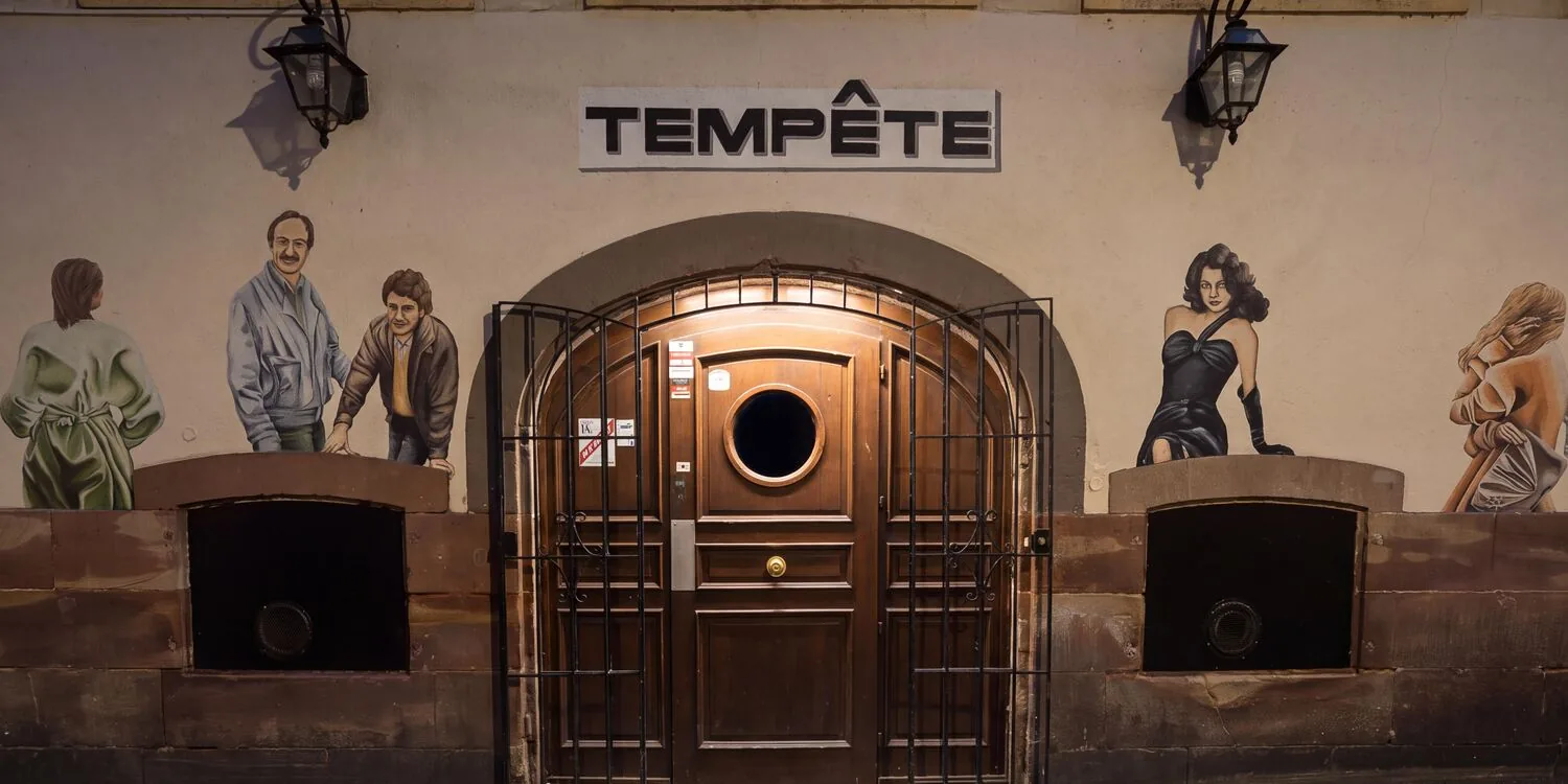 La porte voûtée de Tempête, avec son hublot, sous l’enseigne