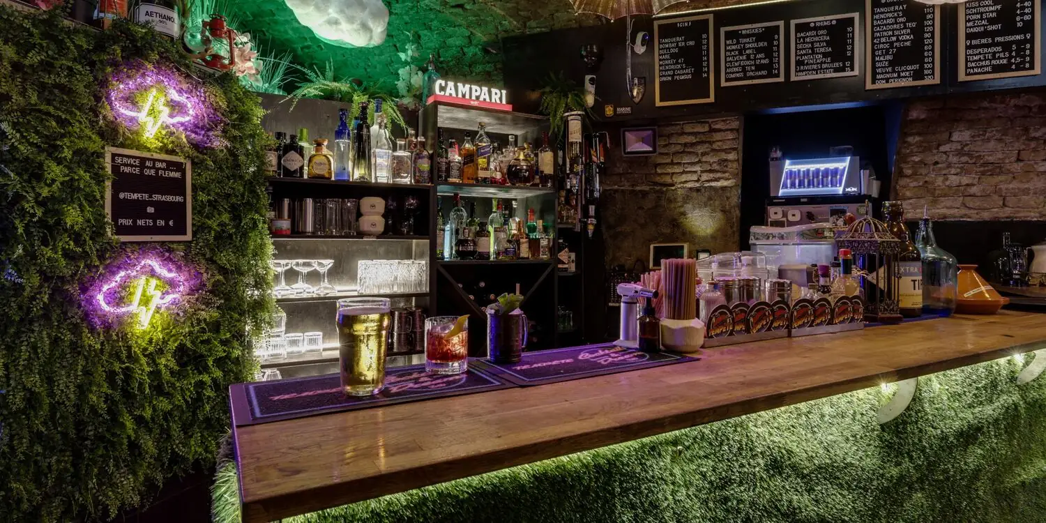 Le bar, ses ardoises, son mur végétal et ses néons
